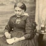 Mary Seacole sat down with medical bottles on a table next to her.