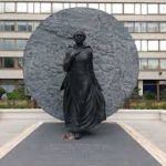 An image of the memorial statue of Mary Seacole. The statue is completely cast in bronze and stands tall in the gardens of St Thomas’s Hospital, in London